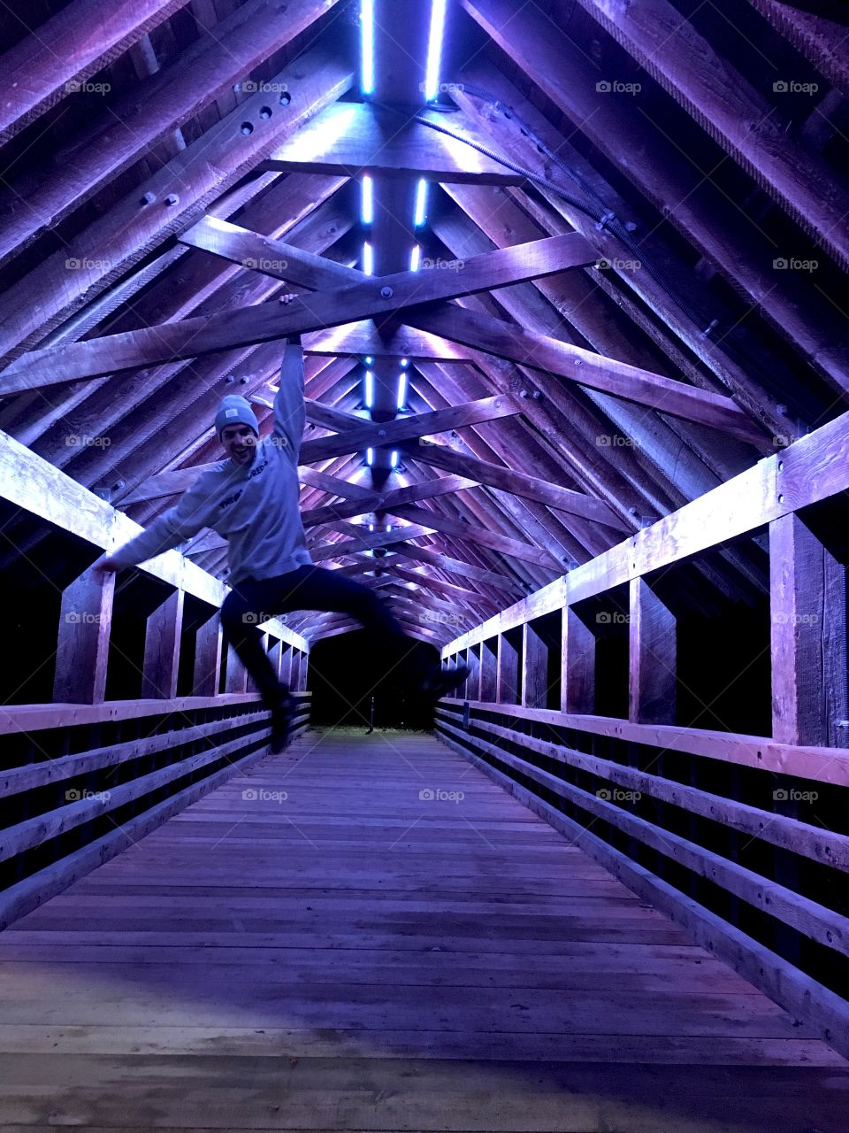 Man hanging on bridge