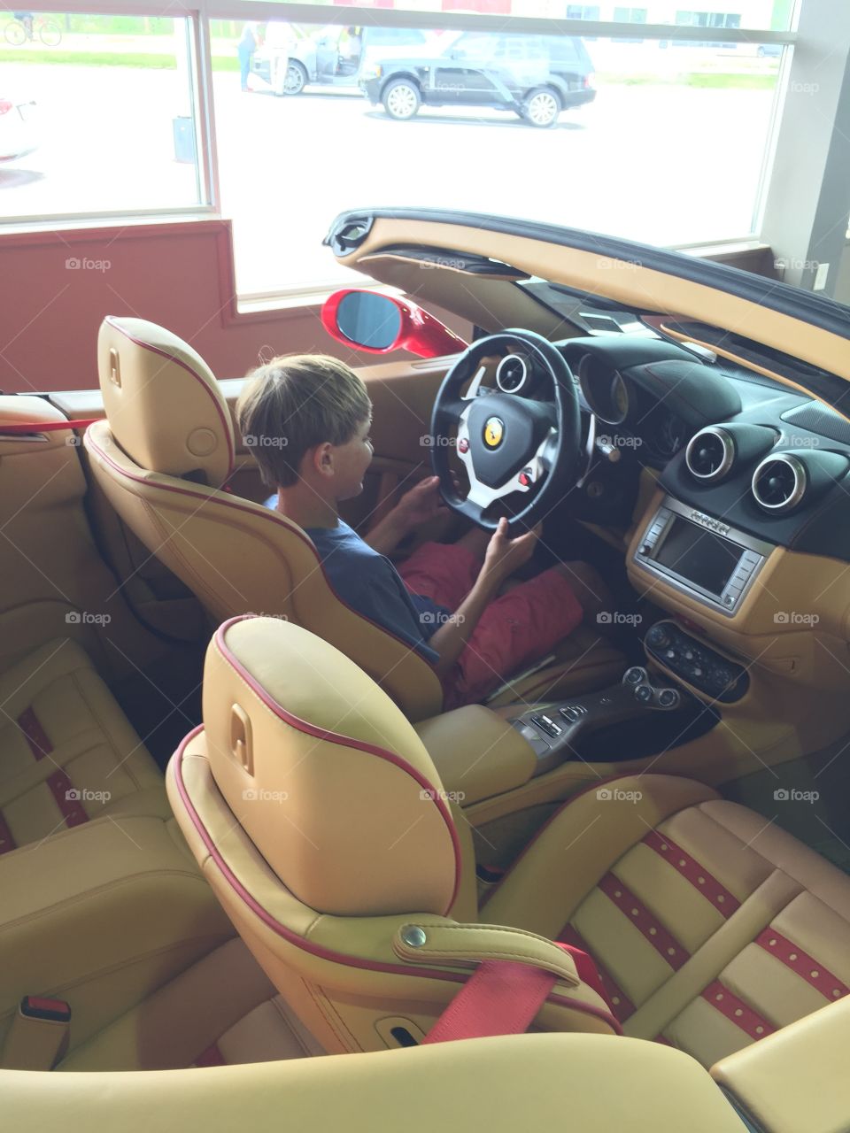 Big Dream'n. Boy sitting in a Ferrari. 