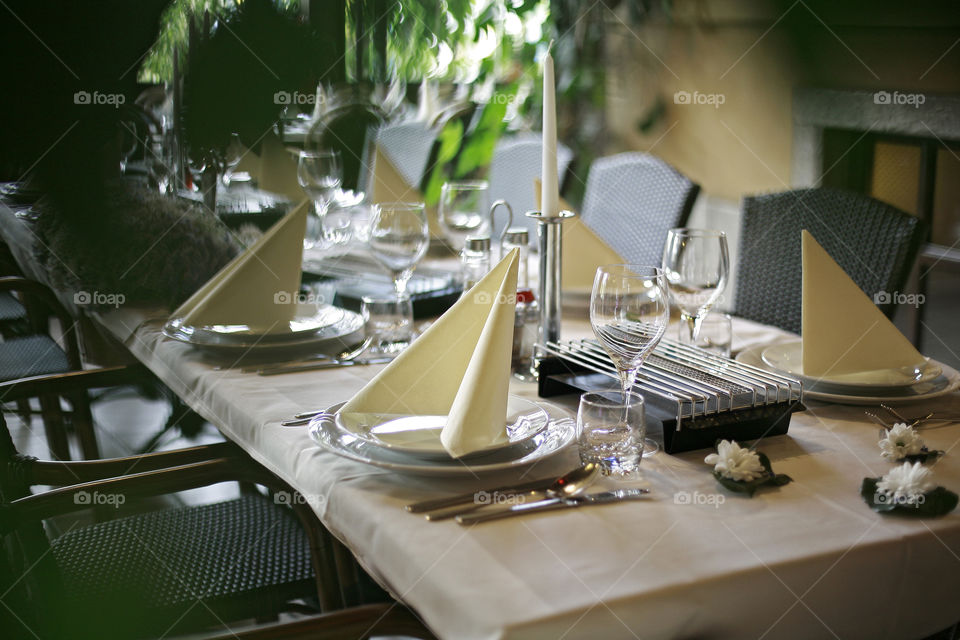 table set for wedding. plate, napkin, candle,glasses on decorated table