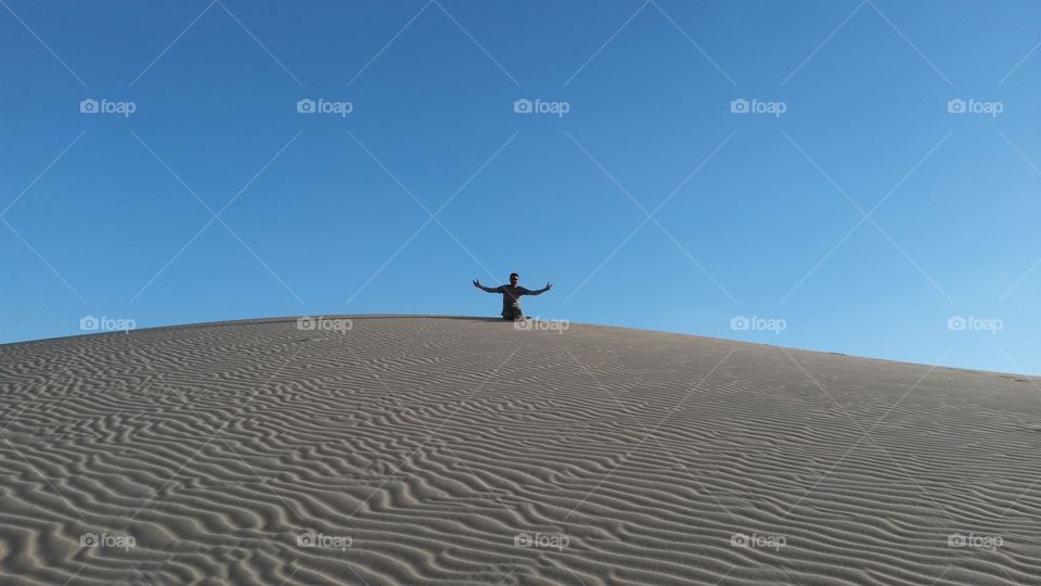 Man sitting on white sand in desert