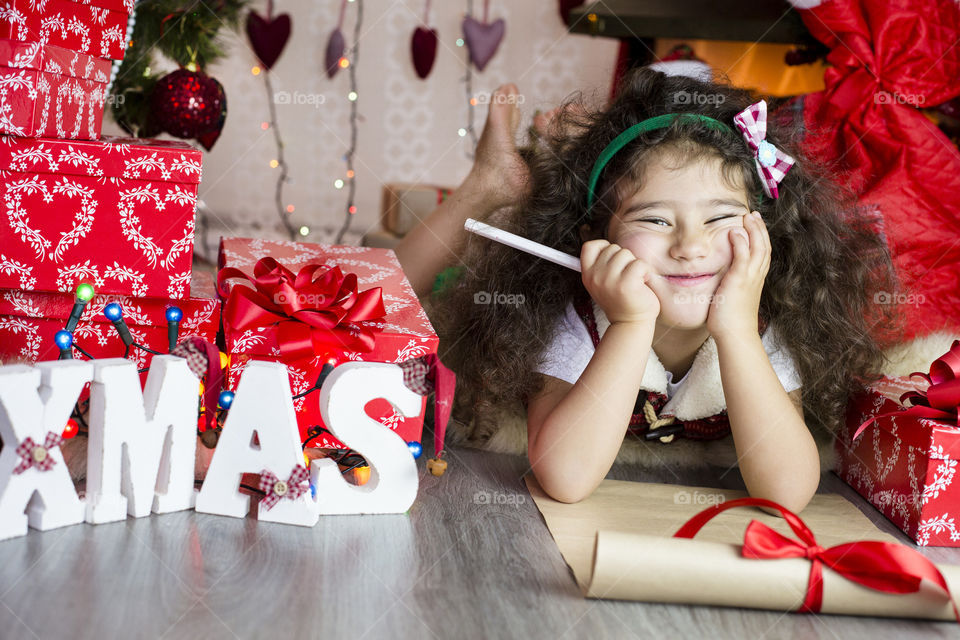 Cute girl lying on floor with Christmas gifts