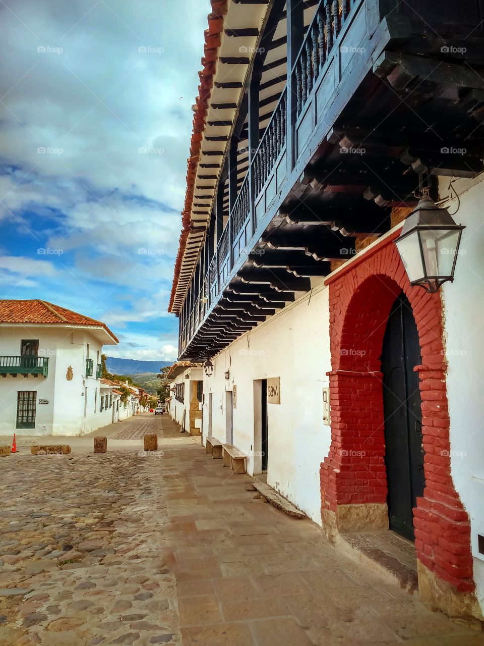Villa de Leyva, Boyacá, Colombia - Calle con portal farol y balcón. Arquitectura colonial.  Street with lantern portal and balcony.  Colonial architecture. Vertical