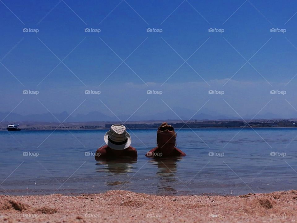 A view on two people in the sea from the beach