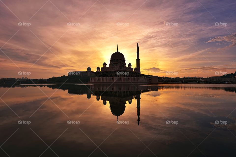 Silhouette mosque reflections at sunrise