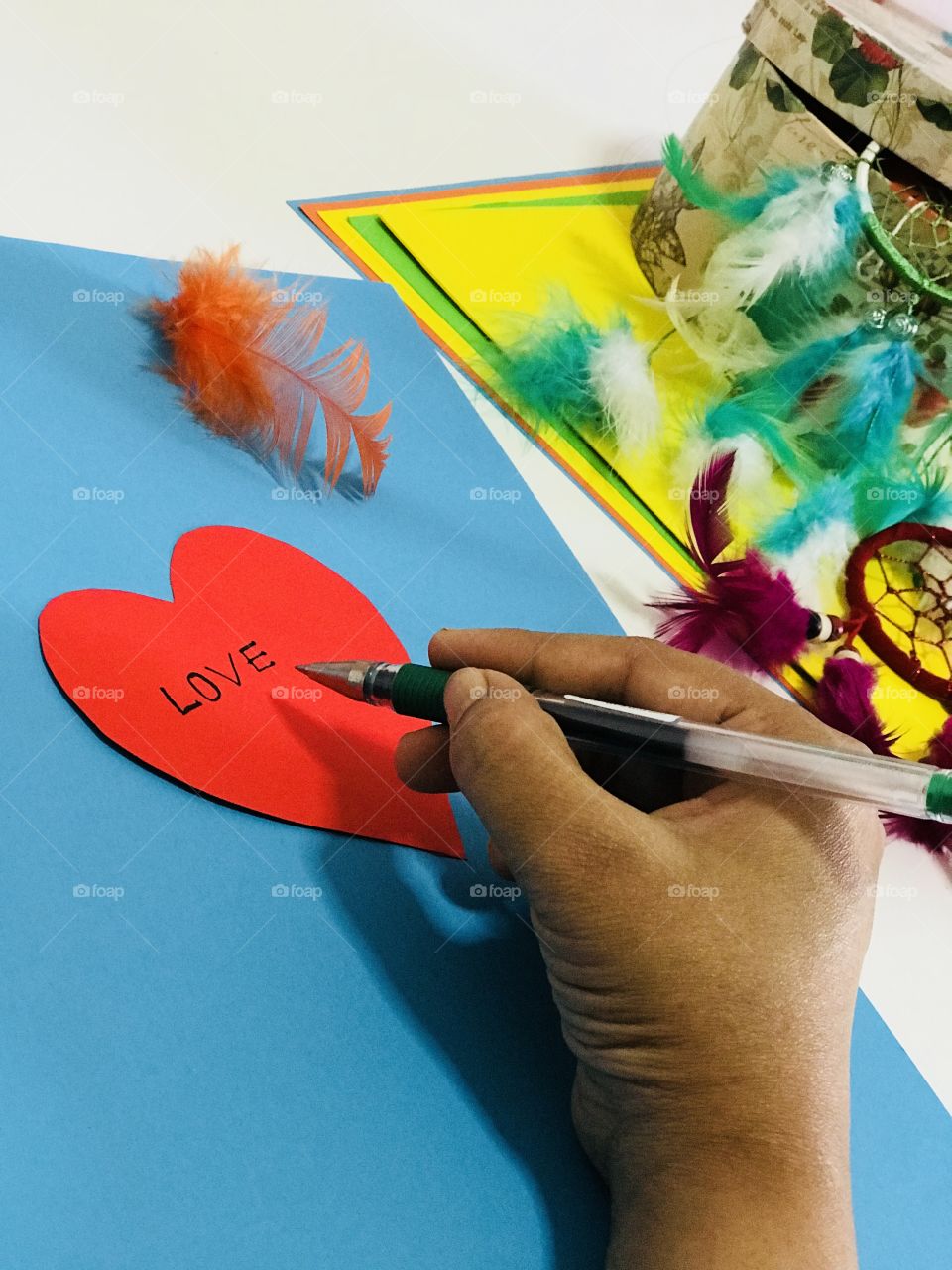 Writing love letter in a Creative way, with colourful papers and feather