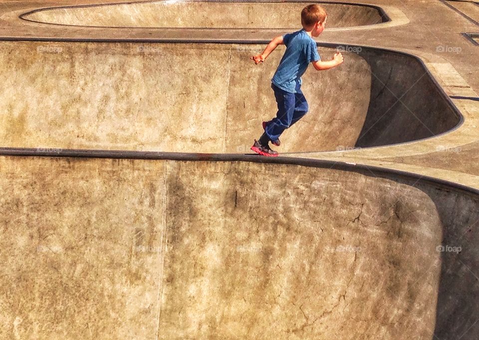 Daredevil Boy Running. Boy In Urban Concrete Setting Running During The Golden Hour
