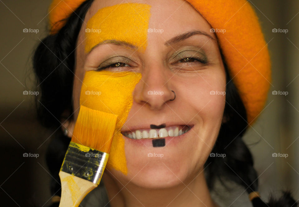 Painted face in yellow, smiling portrait