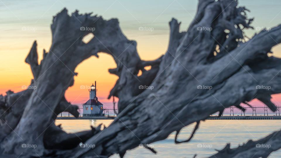 Through Driftwood Rests the Sunset Lighthouse Begging to Light the Way