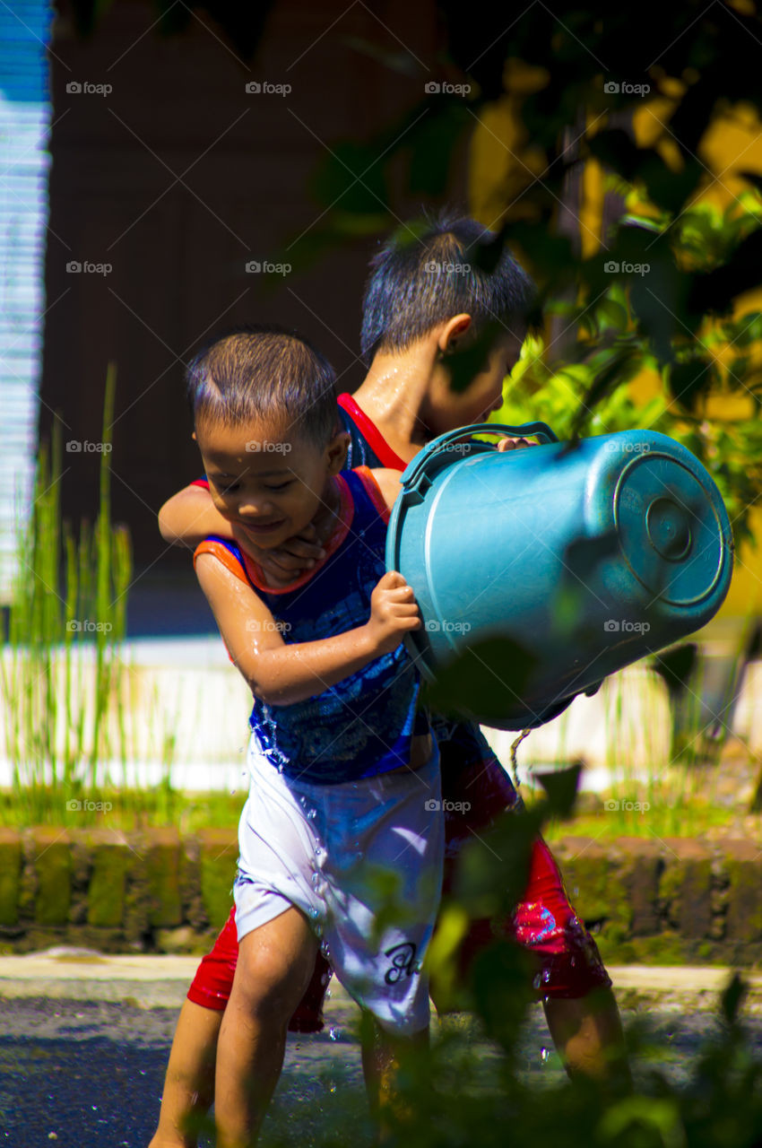 Children playing with water in bucket