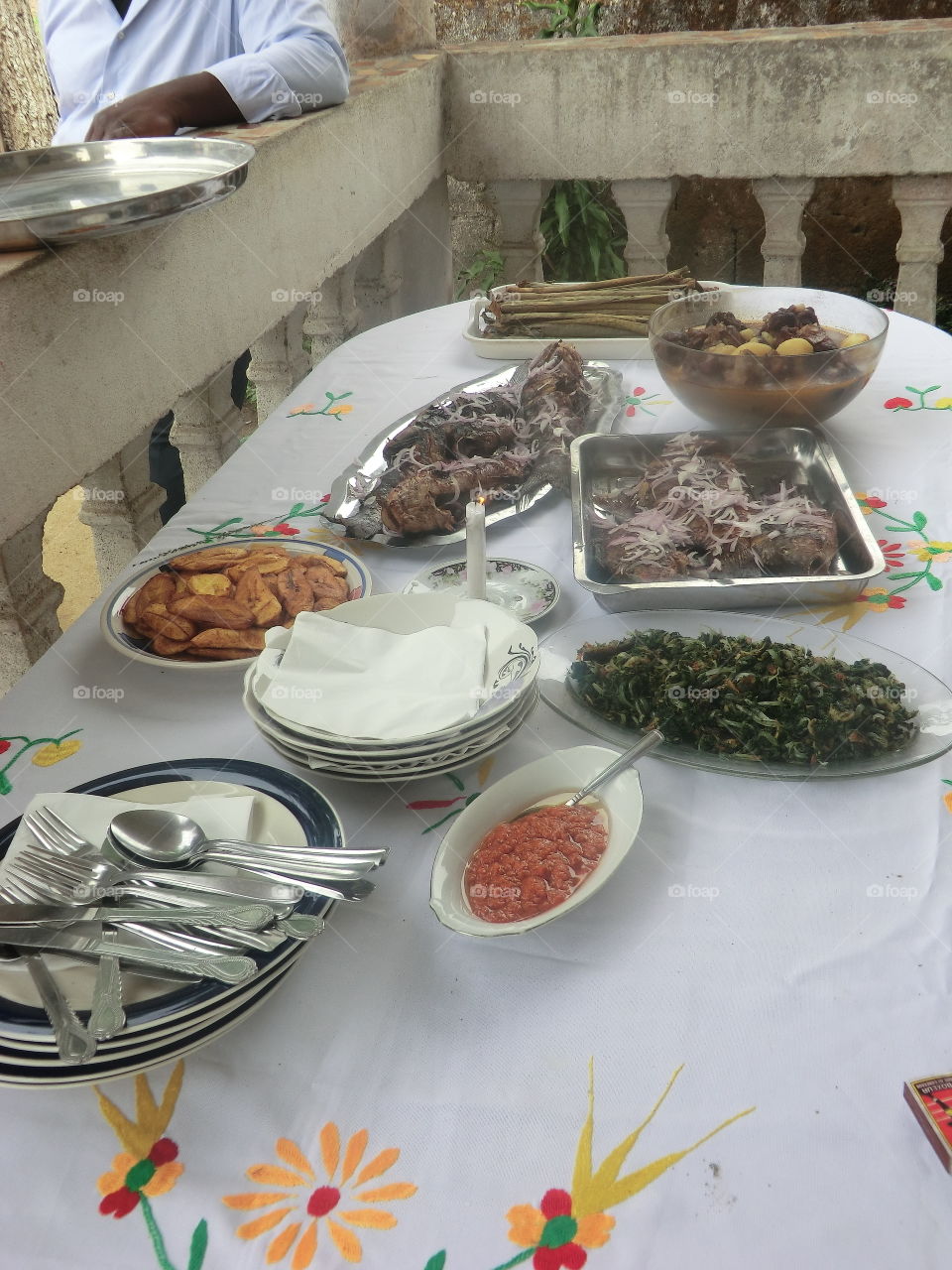 Tipical lunch in Cameroon, fried banane plantain , river fish coocked on the carbon grill , batôn de manioc , beef meat and  potatoes  some vegetables and spicy sauce