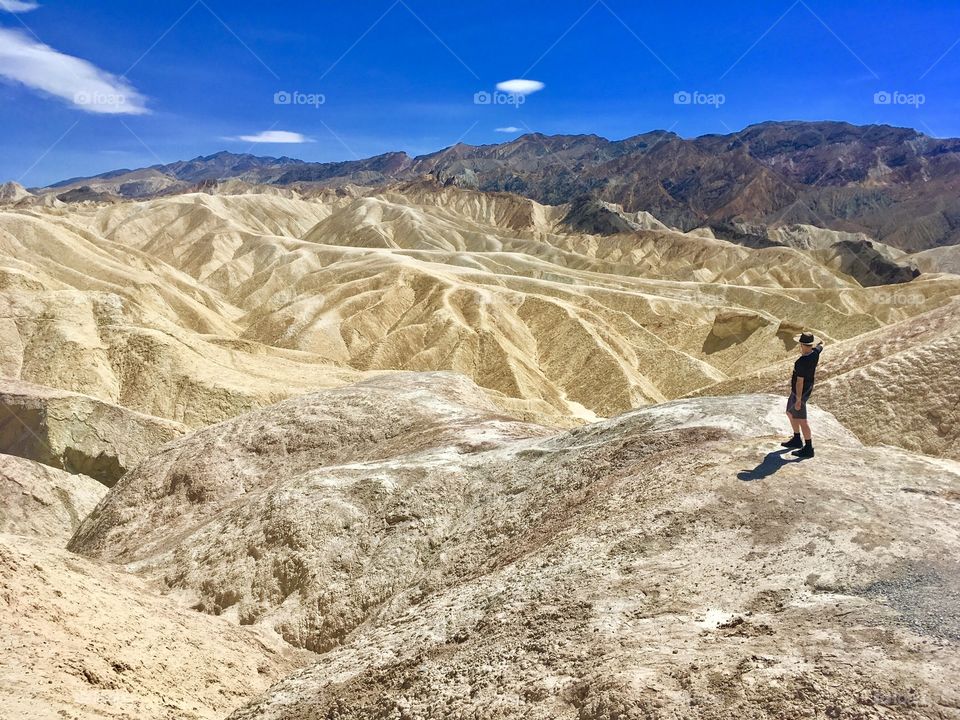 A lone man looks out over a series of sandy ridges at a national park in Nevada 