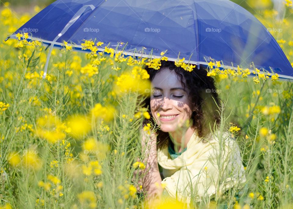 Spring Portrait of a Beautiful Young Girl on Background of Rapeseed Field