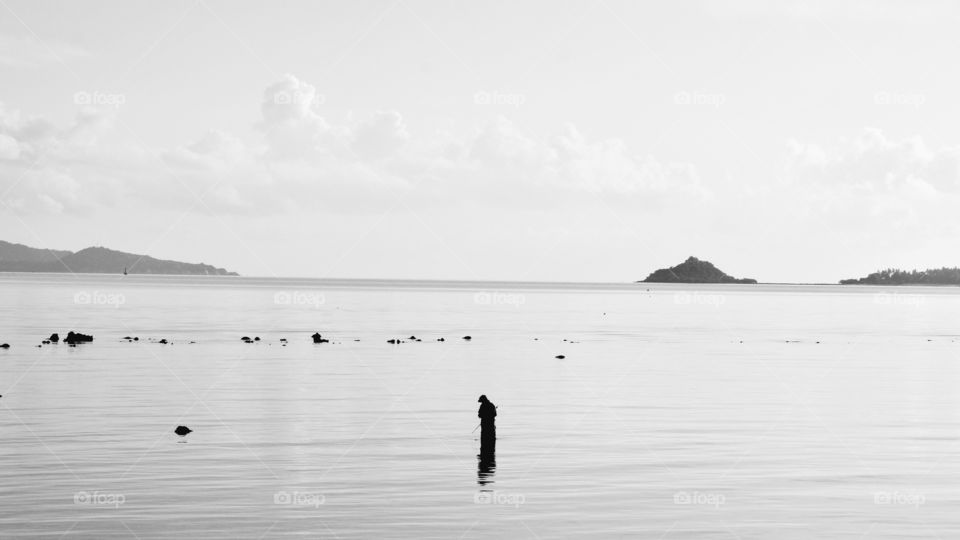Silhouette of fisherman on sea