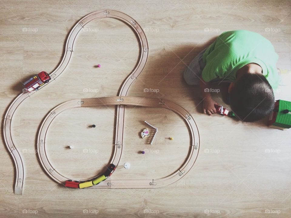 Kid having fun with a wooden train set