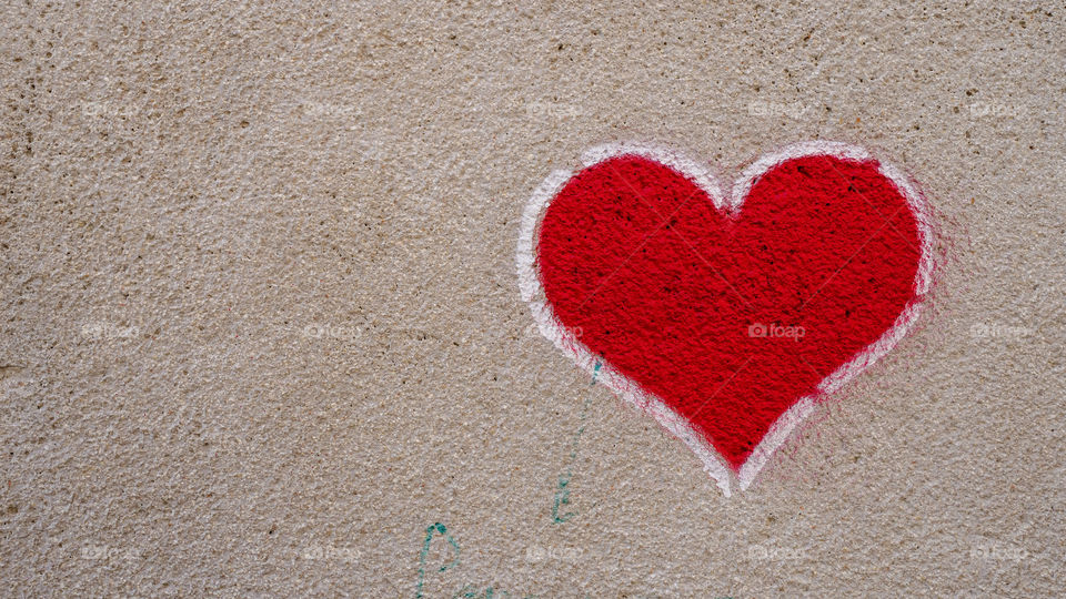 Heart shaped graffiti on stone wall symbol for love