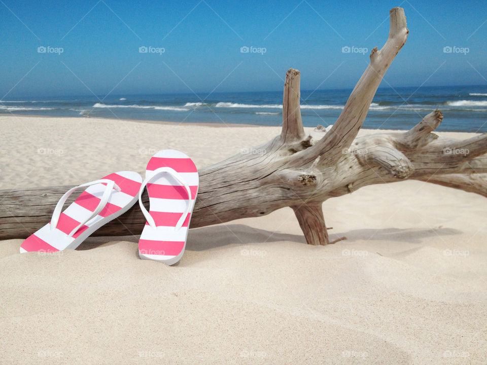 Pink flip-flop on beach