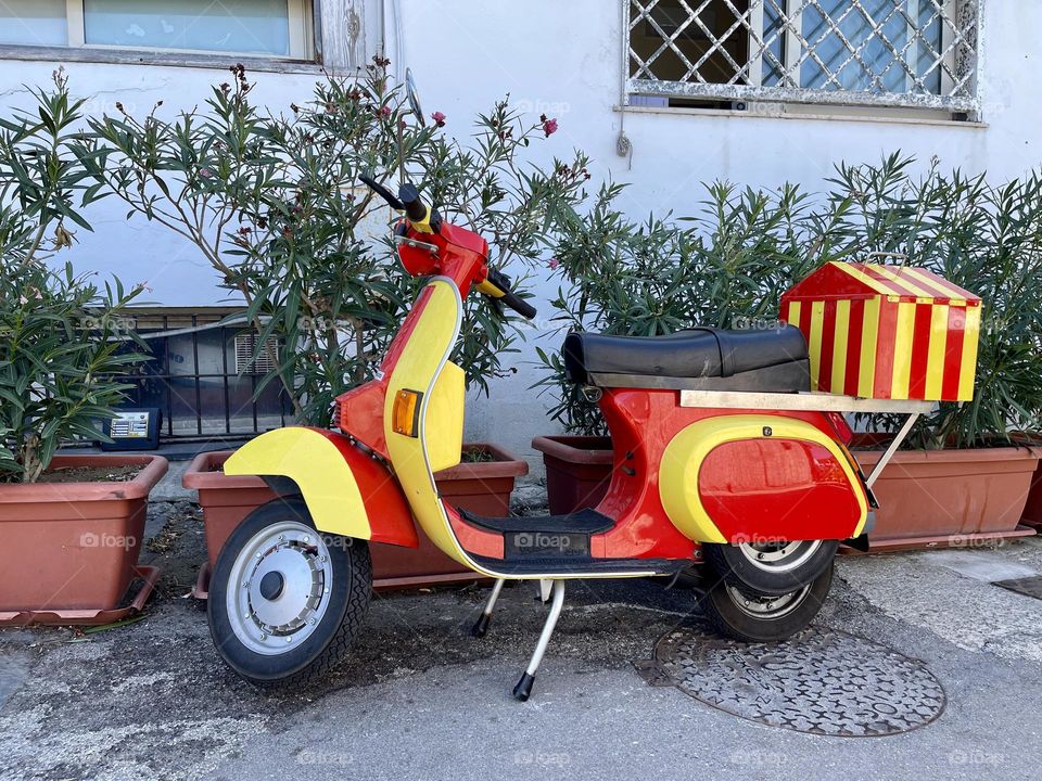 Yellow and red scooter outside 