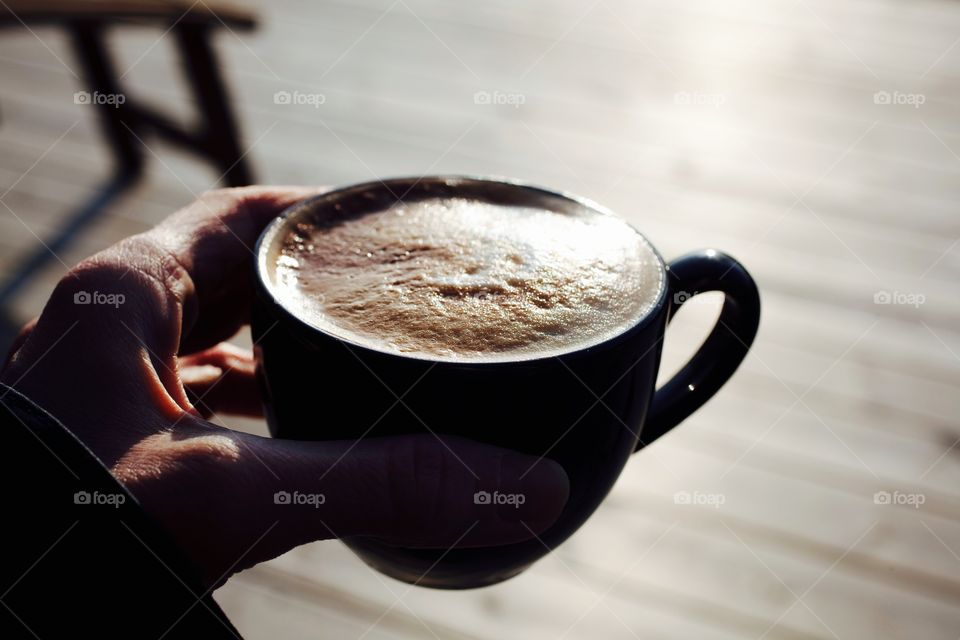 Human's hand holding coffee cup