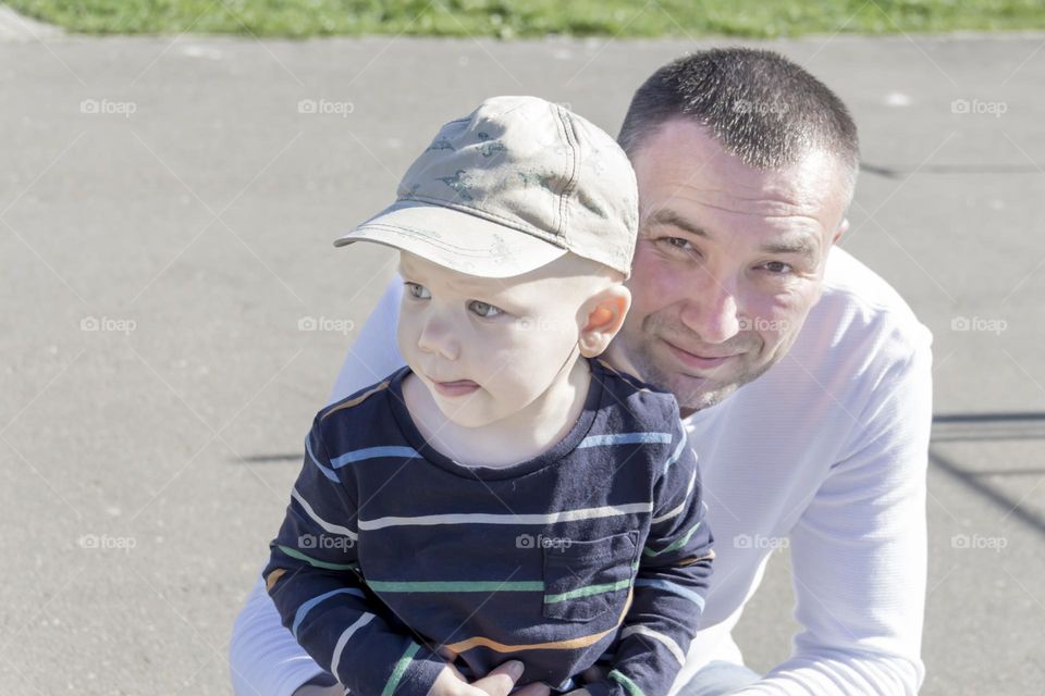 A caring father spends time with his beloved son in the park in the fresh air.