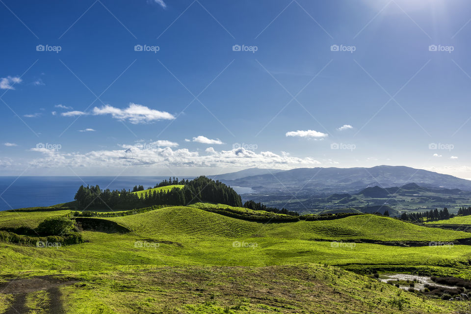 View from the road to Sete Cidades in the island of Sao Miguel, Azores, Portugal. Meadows with ocean in the background