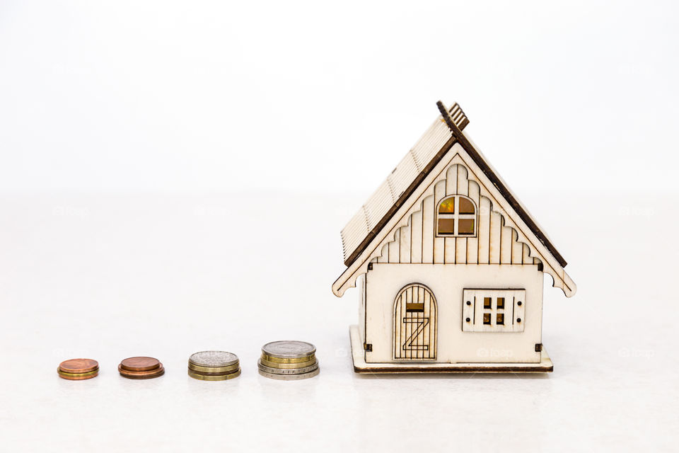 toy house and coins on a white background