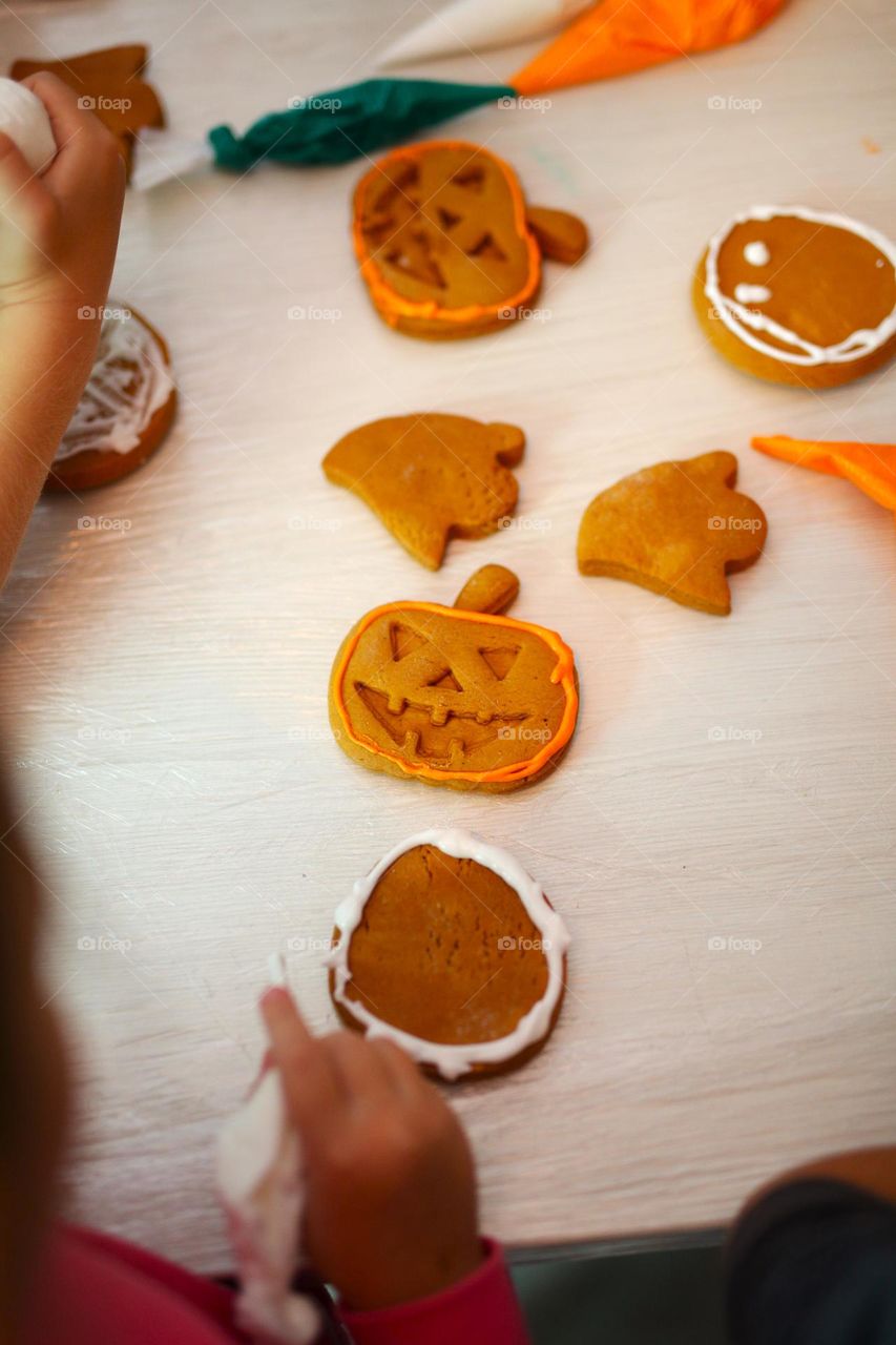 seven year old boy decorating handmade cookies for Halloween