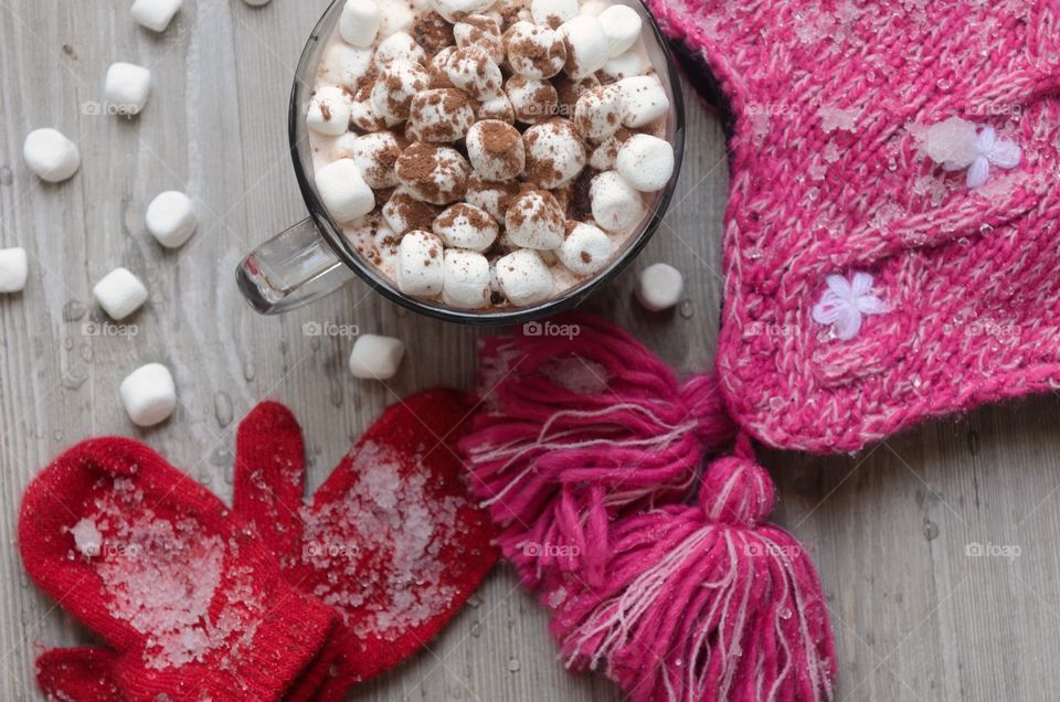 Marshmallow with cocoa powder near woollen clothes