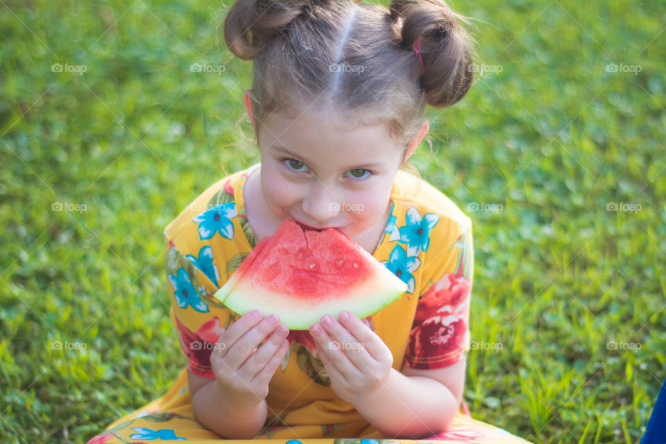 Young Girl Eating Watermelon on the Grass 