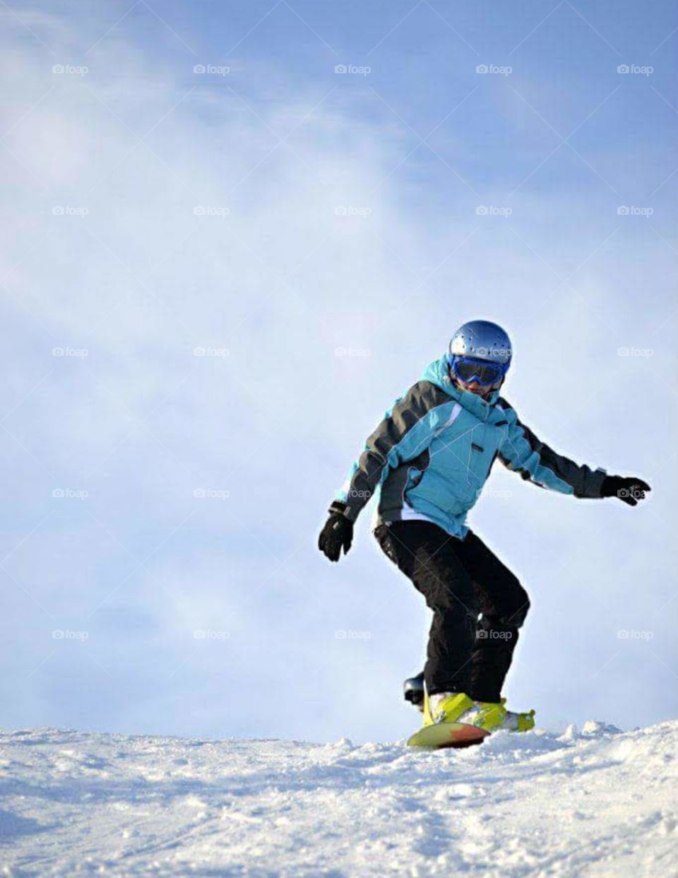 snowboarder in a blue suit rolls on the snow
 