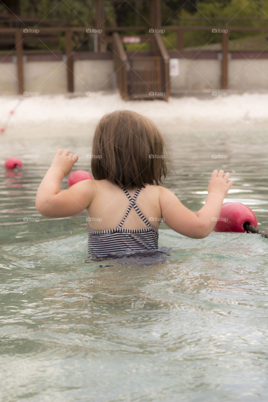 cold water. little girl walks into cold water