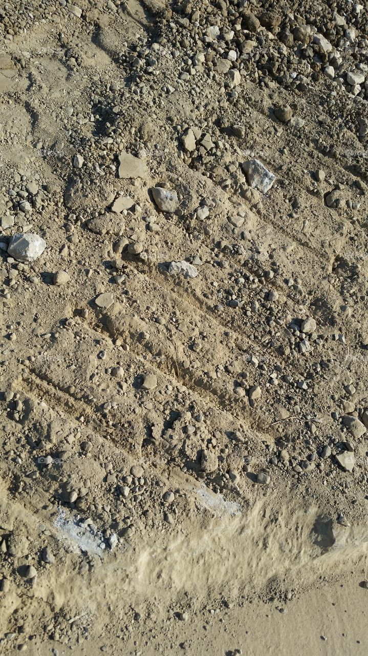 lines and tread marks on dirt and rock