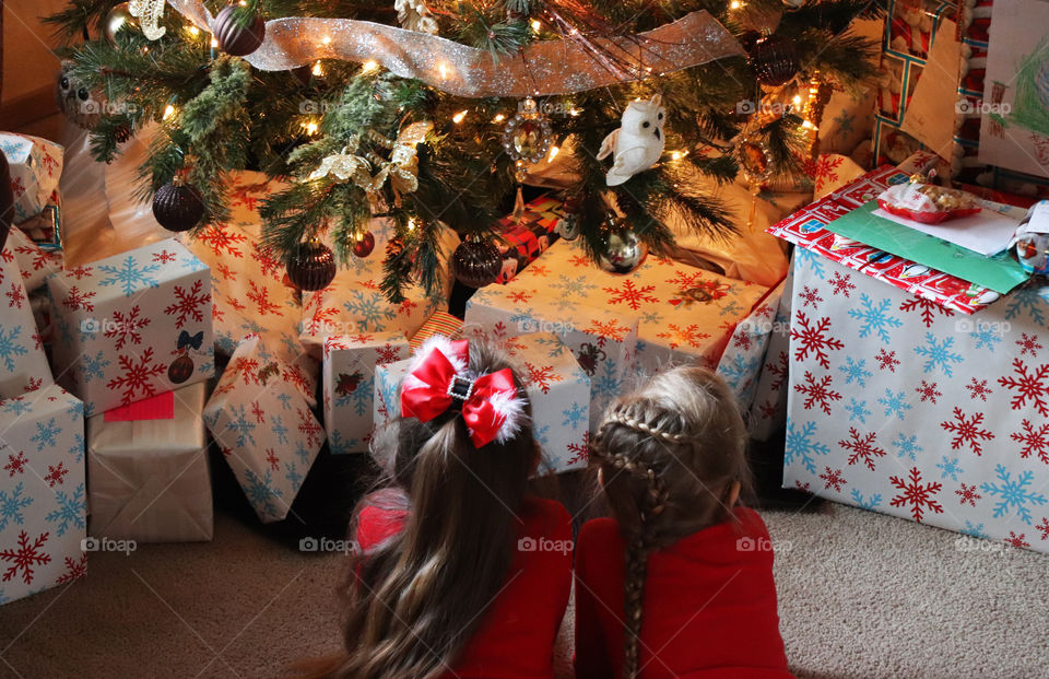 children laying by the Christmas tree
