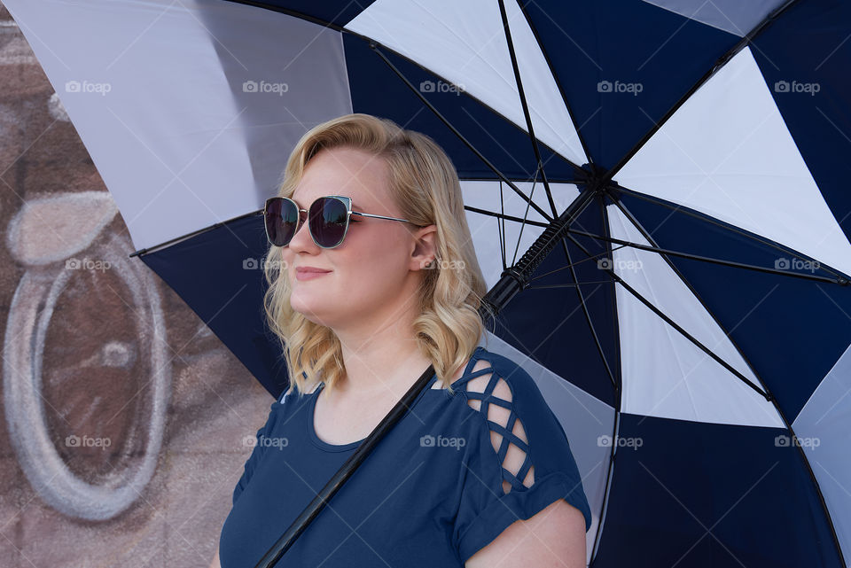 Close up of woman smiling holding Totes umbrella 