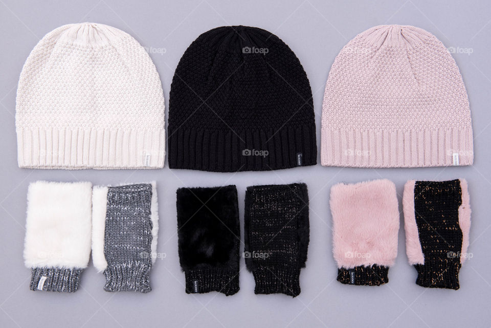 Flat lay of three sets of beanie hats and fingerless gloves