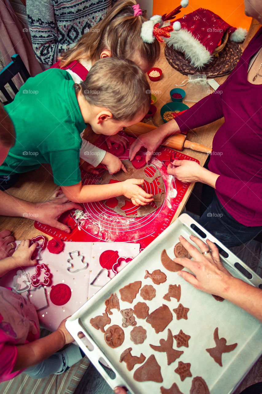Baking Christmas cookies. Christmas gingerbread cookies in many shapes decorated with colorful frosting, sprinkle, icing, chocolate coating, toppers, put on table. Baking traditional cookies. Family celebrating Christmas. Baking at home