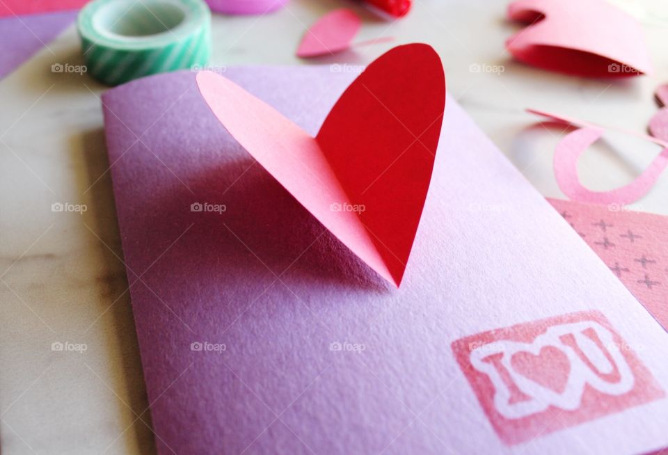 Homemade Valentine's Day greeting cards with stamps and heart cutouts.