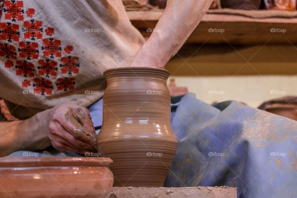 Learning pottery - man making a pot of clay