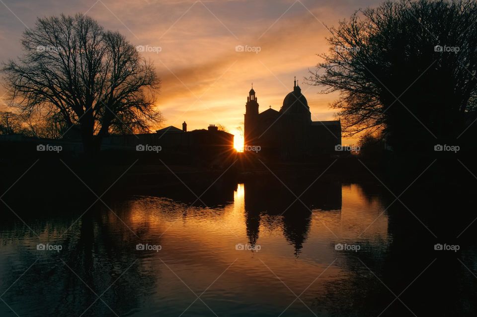 Sunset at Galway cathedral reflected in Corrib river in Galway city, Ireland