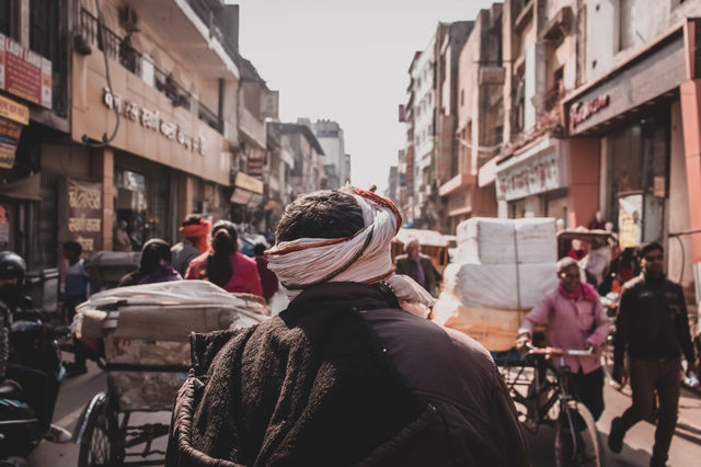 Bustling City Street In India.
A man walks through a busy street as the hustle and bustle of city life moves around him.
