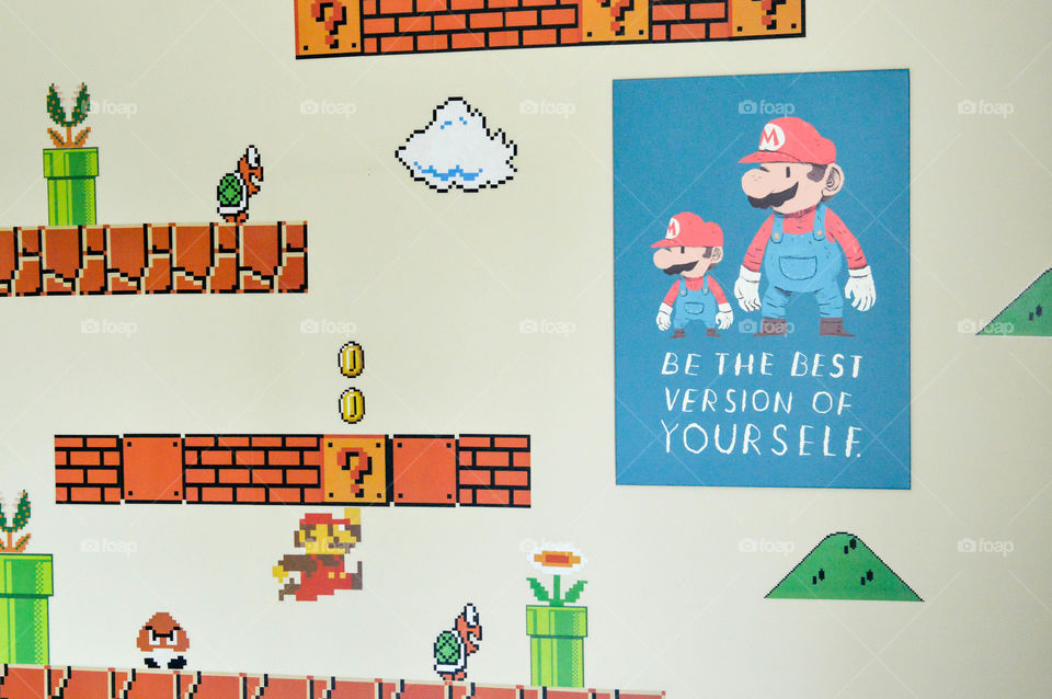 Motivational wall art of super Mario displayed next to super Mario brothers video game graphics