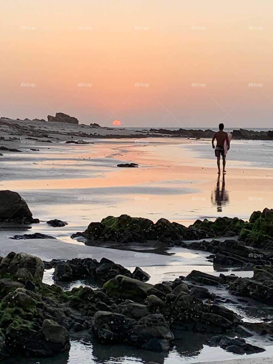Boys with surf walking in the beach at sunset 