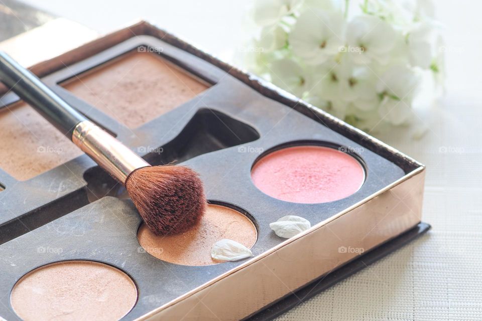 Makeup set with brush and hydrangea flower