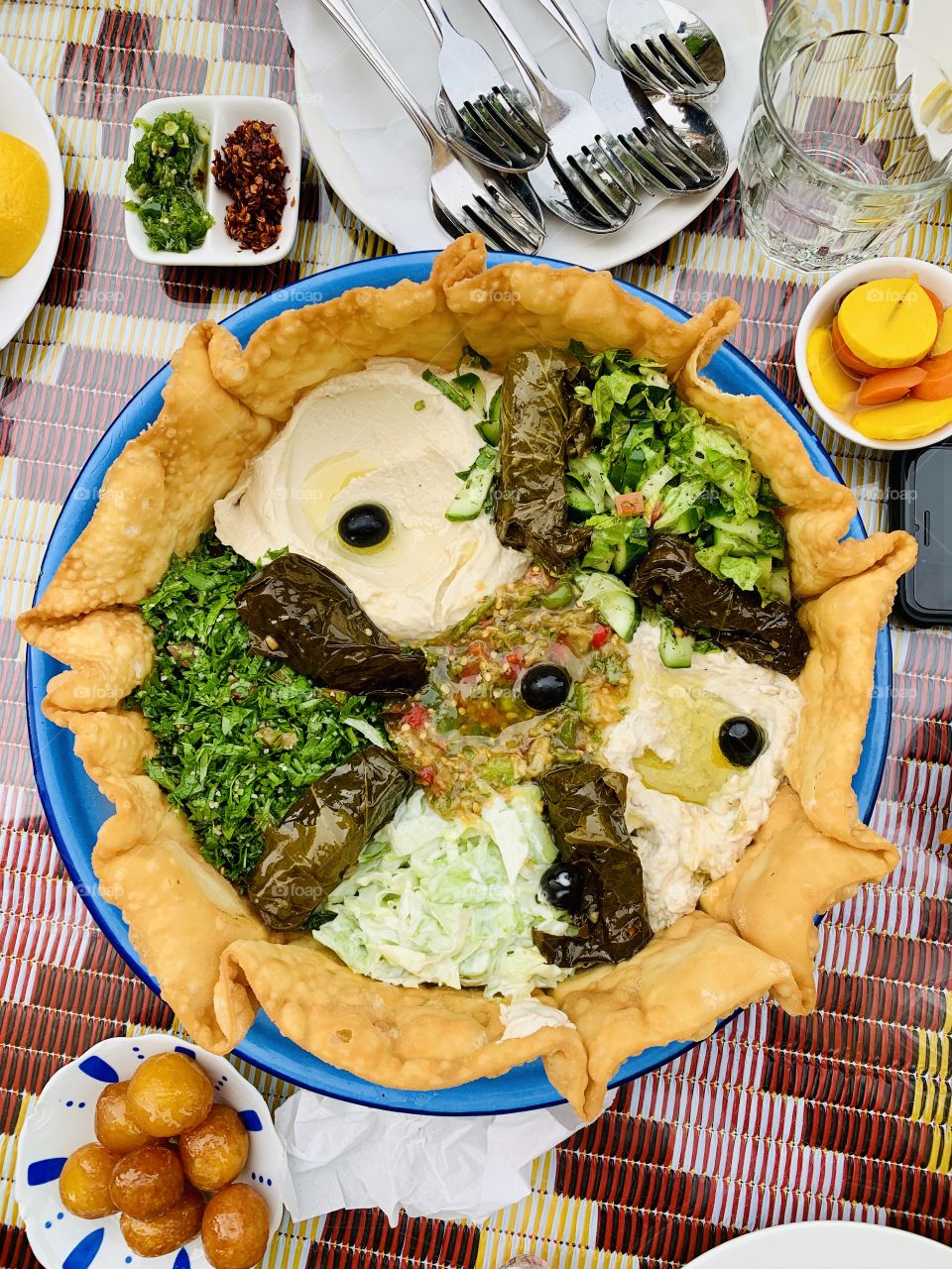 Mix of Arabic appetizers and salad in a crunchy bread with Arabic sweets and spoons