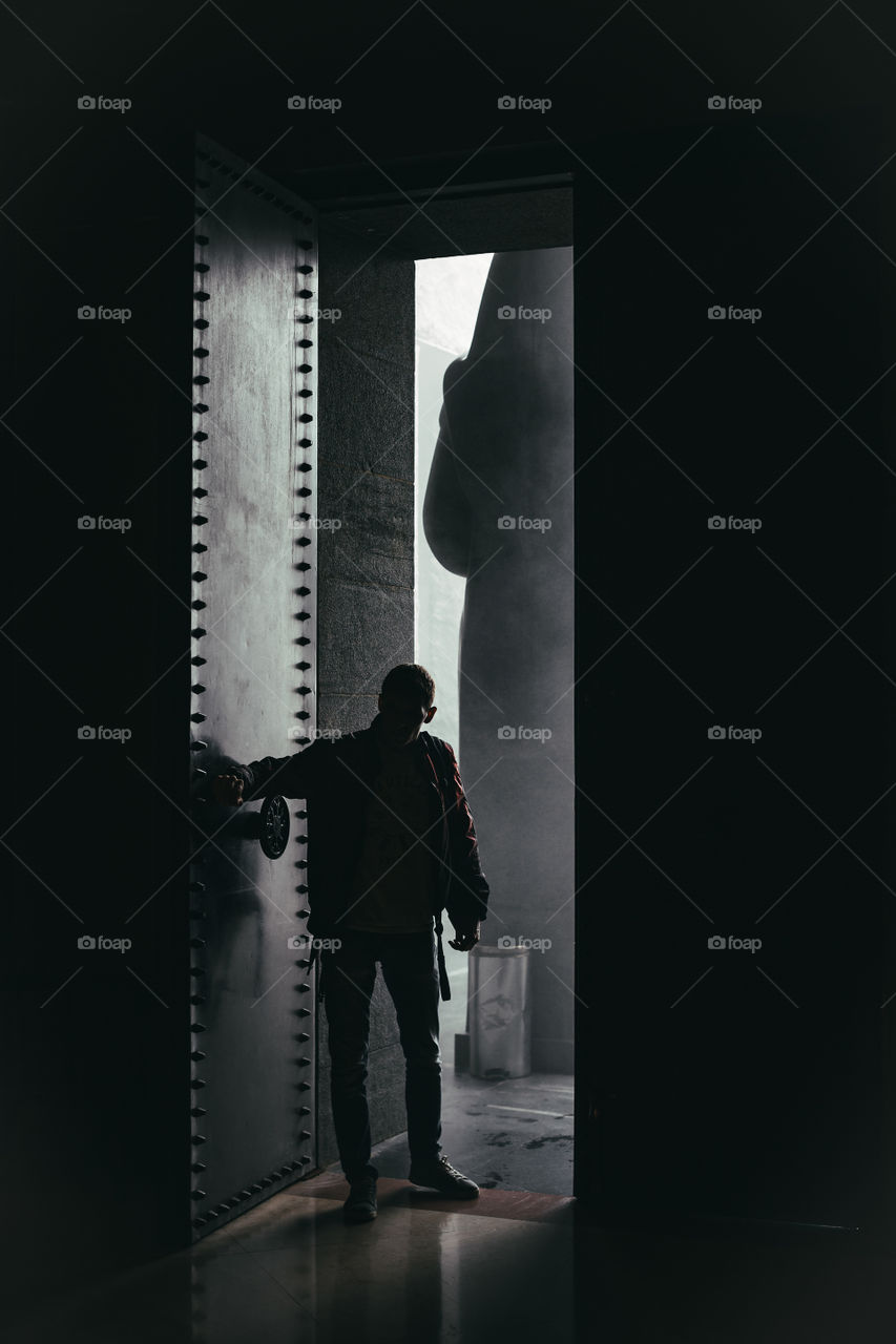 a man enters a crypt with huge doors