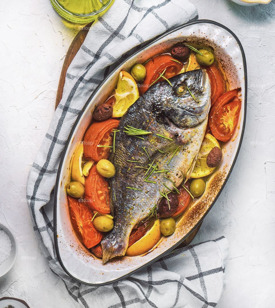 Baked fish with tomatoes and lemons