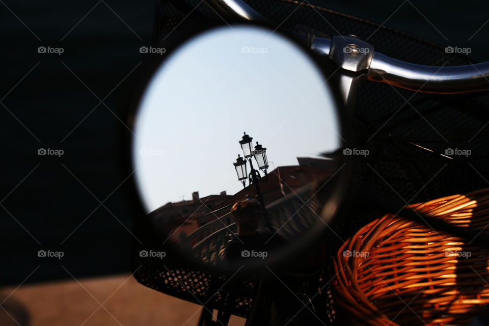 Reflection of a street lantern in a bicycle rear view mirror