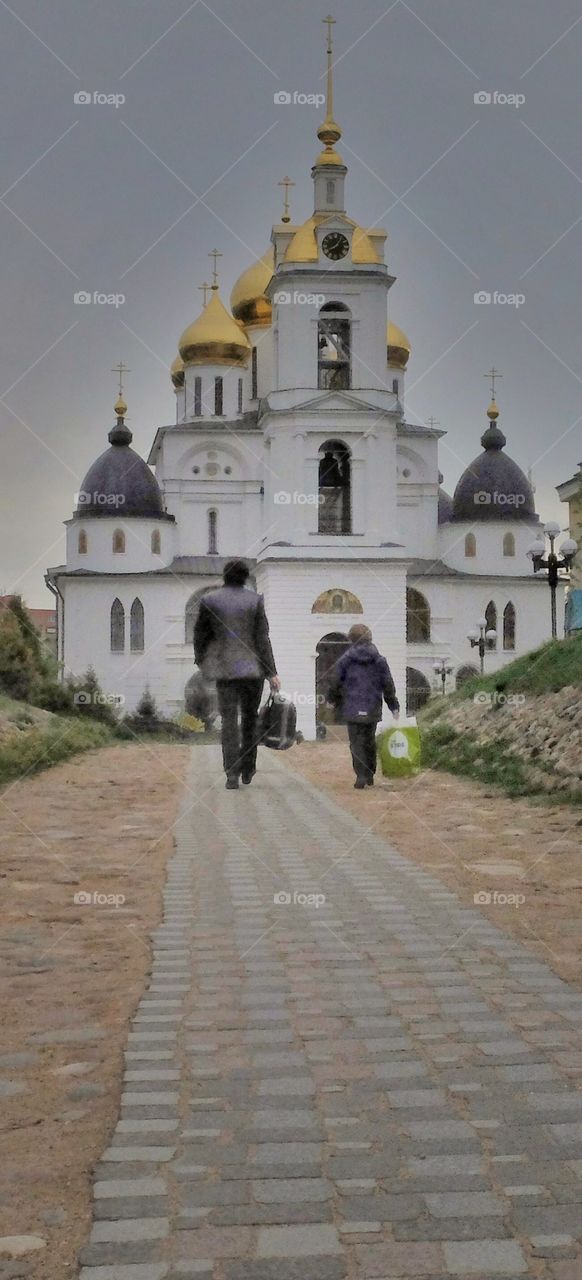 Walk the faith. 
This shot I made in old Russian city called  Dmitrov. I think that man and a boy are father and son. Who knows may be they walk to that church to talk to God. 