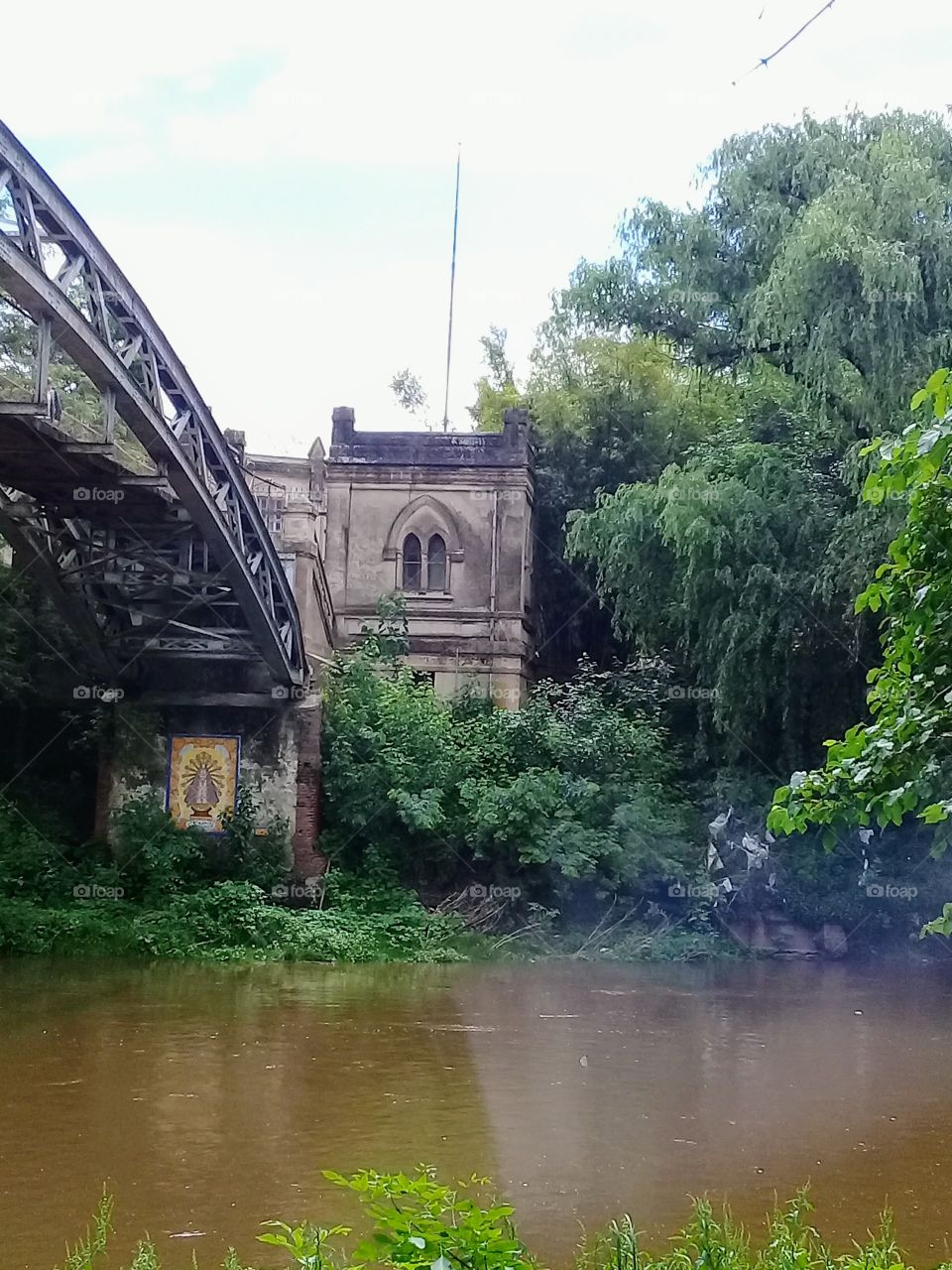 antigua abadía convertida en colegio religioso comunicada con la ciudad por medio de un puente privado que atraviesa un río con frondosa vegetación.
