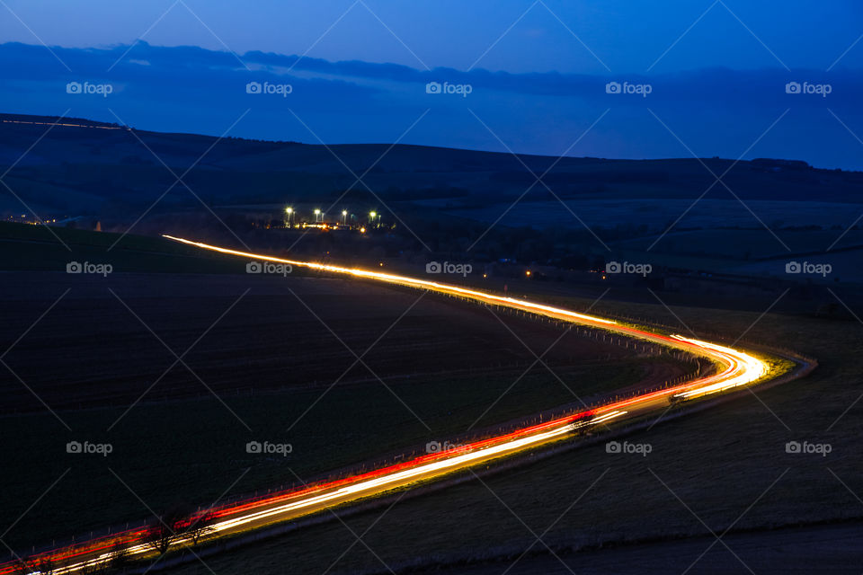 traffic light trails winding along a road at dusk
