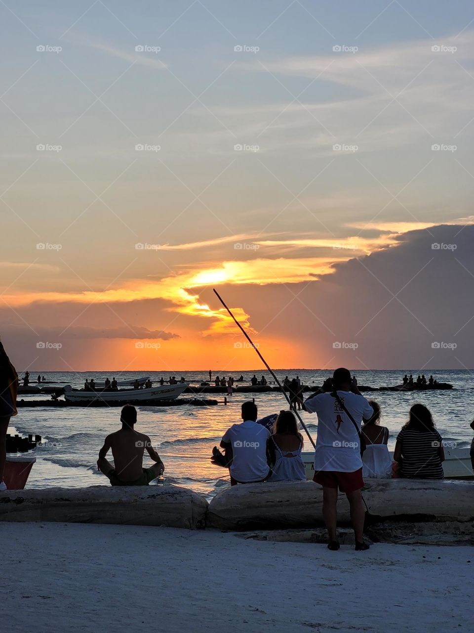 la gente mirando el atardecer en la playa de Holbox